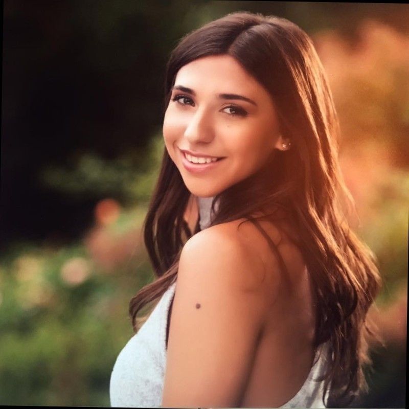 Portrait photo of a young smiling woman with long dark hair