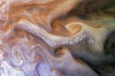 Close-up image of Jupiter's atmosphere featuring swirling cloud formations in shades of orange, brown, and cream, with a prominent pop-up cloud structure and dynamic patterns of turbulence.