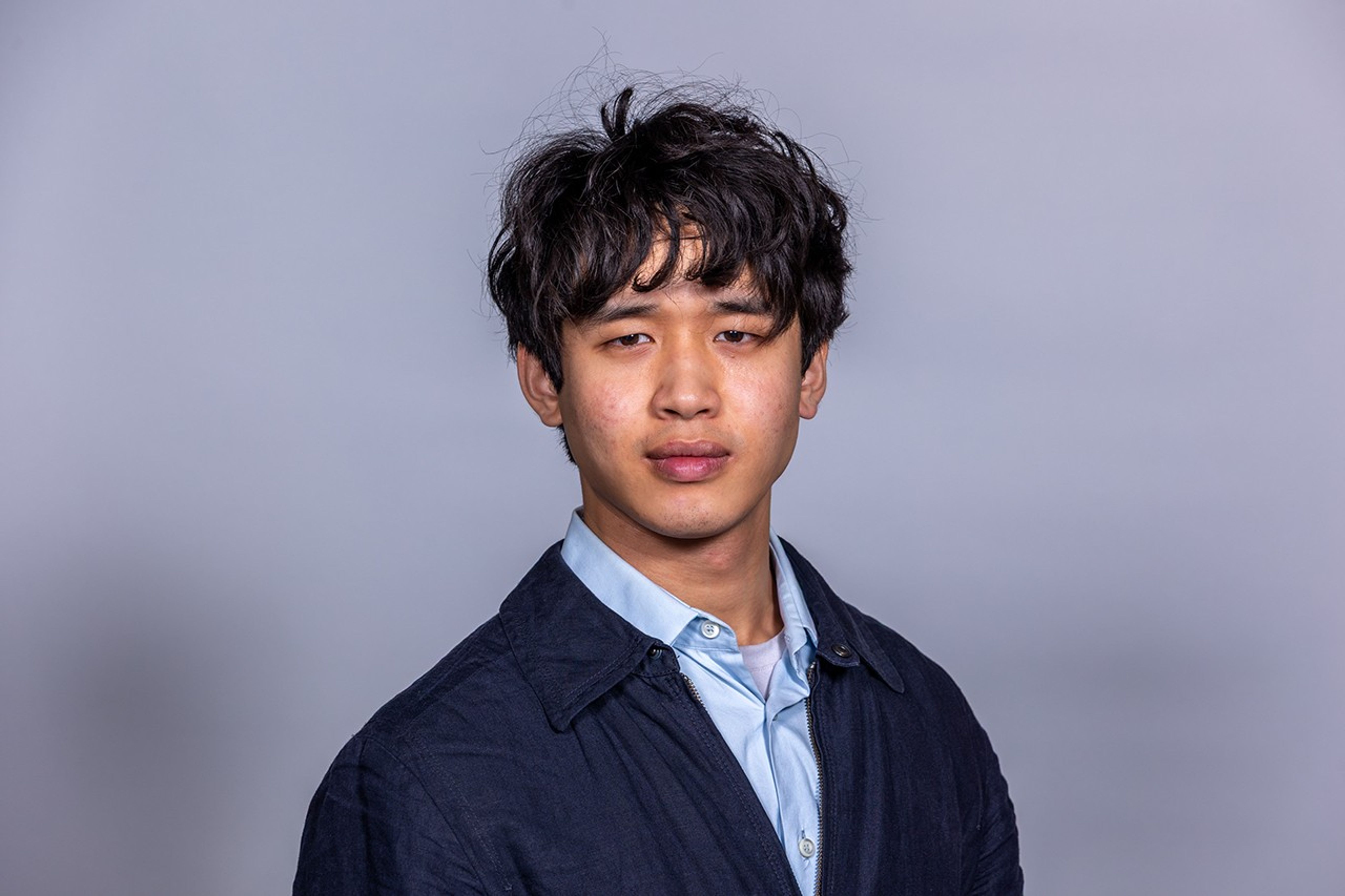 Asian man, Patrick Wang, Undergraduate researcher, Haverford College, in a dark blue overcoat over a light blue button down shirt.