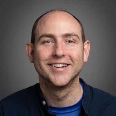 Portrait photo of a smiling man wearing a blue tshirt