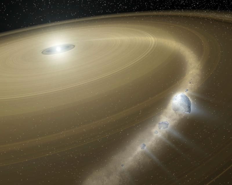 A bright white object lies in the distance. It is surrounded by a small black space, which is in turn surrounded by a large gold-colored dusty disk of debris that fills most of the image. The disk is full of rings, indicating that the material in the ring is orbiting the central star. Across the flat expanse of this disk, a lighter, fuzzy band arcs from near the star to the outer edge of the disk. As this arc reaches closer to the viewer, the rocks and particles within it are visible.