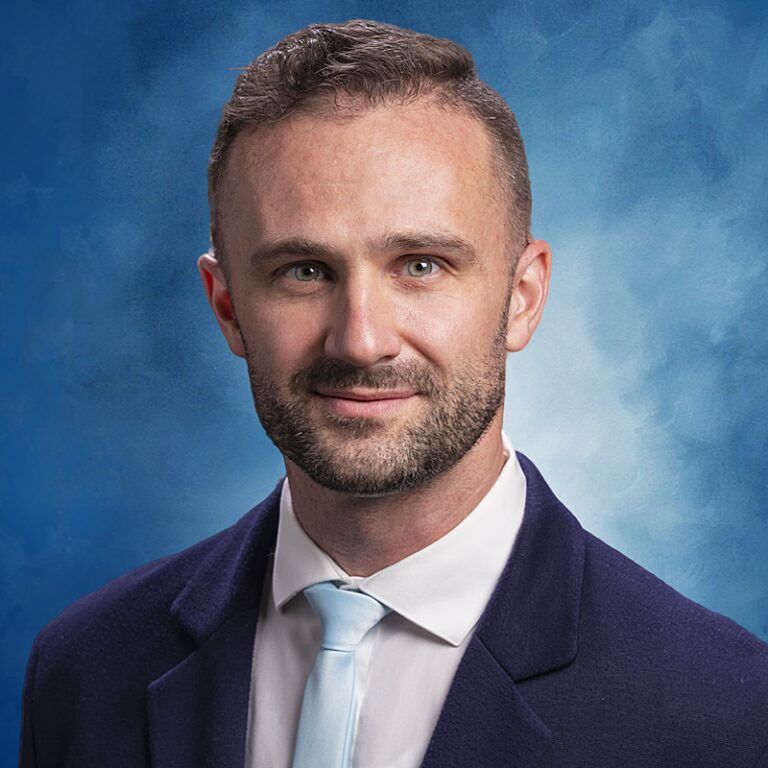 Portrait photo of a smiling man wearing a suit