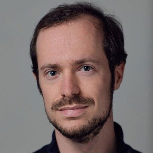 Headshot photo of a young man with a mustache