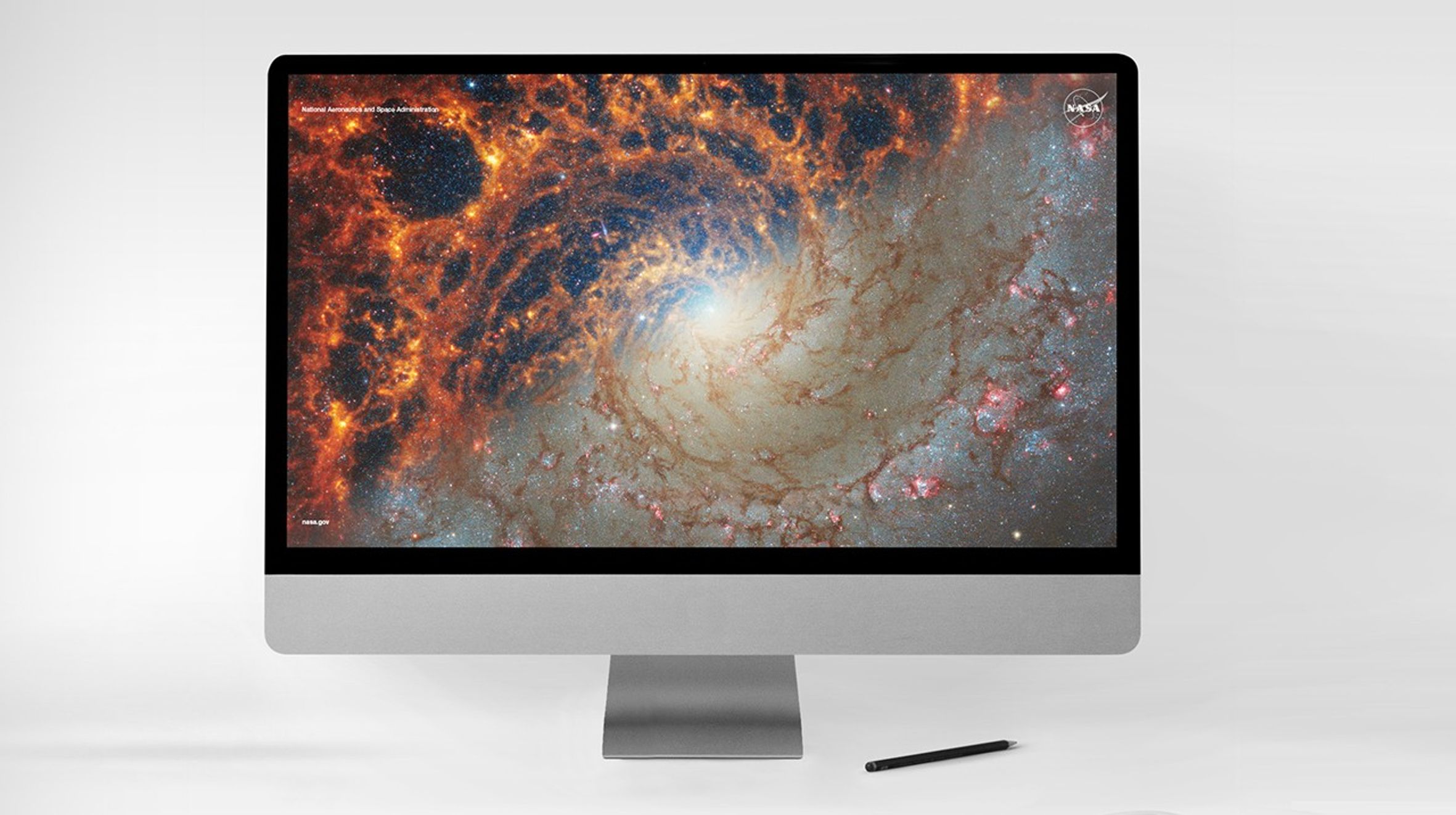 Desktop computer screen with an colorful image of a spiral galaxy and the NASA logo in the upper right corner.