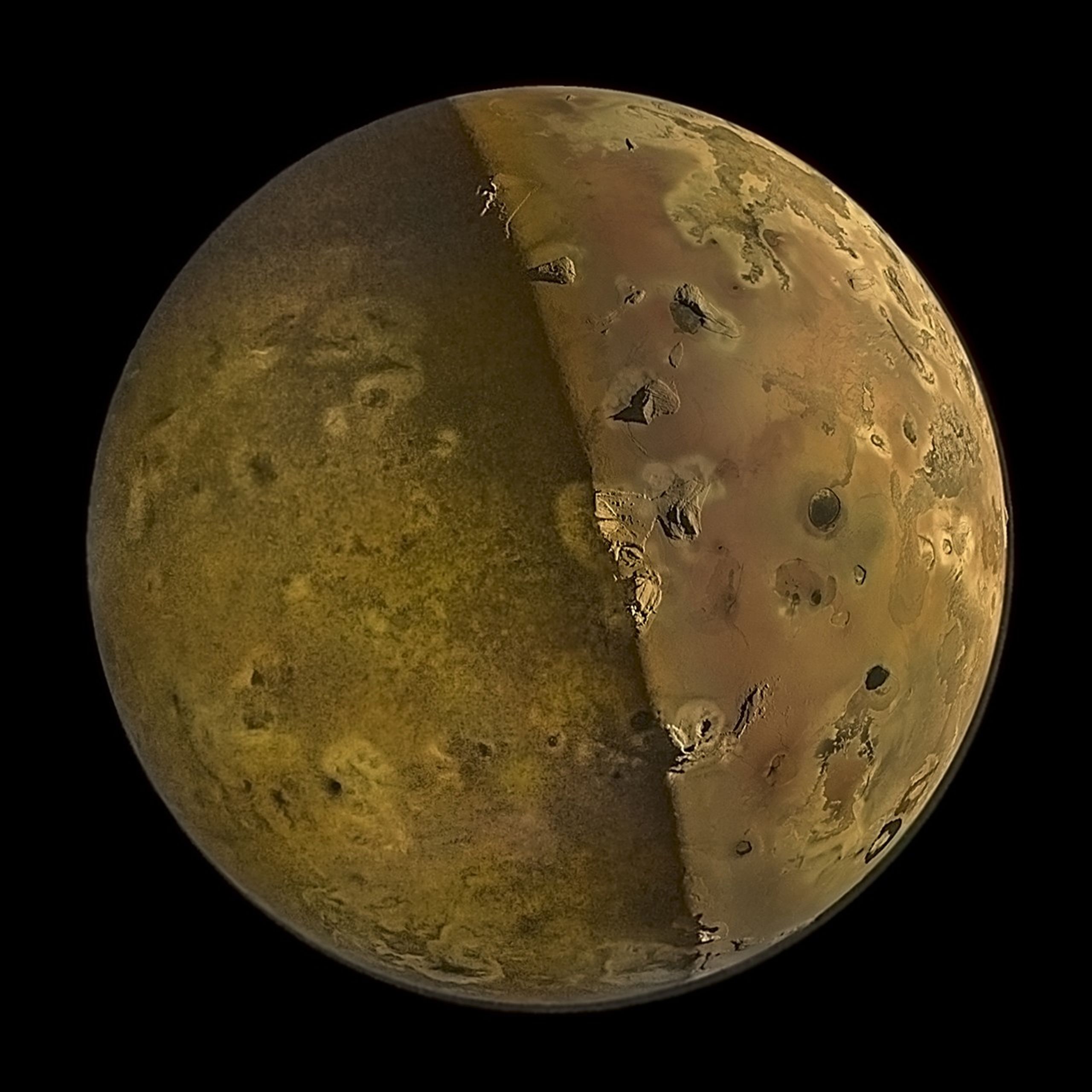 Jupiter's moon Io appearing golden-tan against the blackness of space, half the moon bathed in shadow, half in light, bisected vertically, with mountain peaks and volcanos pockmarking the surface.