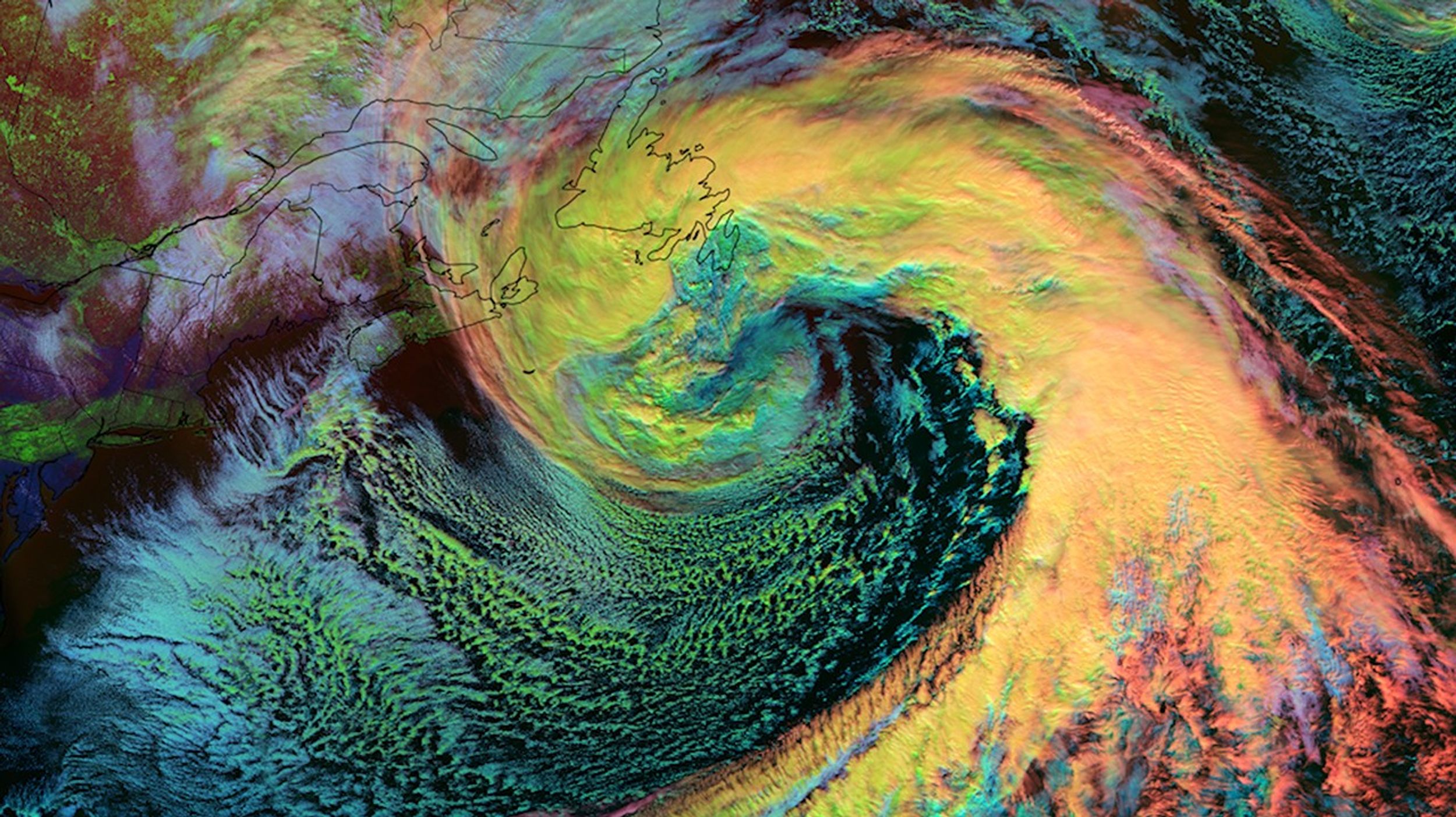 Imagen satelital realzada obtenida con el Sistema Conjunto de Satélites Polares (JPSS) de NOAA que muestra un enorme sistema de tormentas del noreste, un llamado “nor’easter”, sobre el océano Atlántico el 14 de febrero de 2024. La tormenta se ve como una dramática estructura espiral con una brillante representación en colores añadidos: las zonas en amarillo brillante y naranja en el centro indican nubes de hielo espesas y de gran altitud, mientras que las regiones verdes y azules alrededor de los bordes representan formaciones de nubes más cálidas. La imagen muestra la rotación clásica en sentido contrario a las agujas del reloj de este sistema de tormentas, que se extiende desde el este de Canadá hasta el sur hacia el Caribe. Los delgados contornos negros muestran las costas de América del Norte. Esta visualización fue obtenida por el instrumento VIIRS, y destaca diferentes tipos de nubes y temperaturas mediante los colores realzados. Este poderoso sistema de tormentas comenzó en el suroeste de Estados Unidos el 10 de febrero, y finalmente se convirtió en un “nor’easter” que ocasionó interrupciones considerables en los estados del centro y el noreste del Atlántico en este país.
