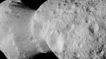 A black and white high-resolution image of asteroid Donaldjohanson captured by NASA's Lucy spacecraft on April 20, 2025. The asteroid appears as a contact binary with two distinct lobes connected by an unusual formation at their junction. The surface is gray with numerous small craters and surface features visible across both lobes. The unique dumbbell-like shape reveals what was previously thought to be a simple contact binary (two asteroids fused together) may have a more complex geological history. This close-up image, taken during Lucy's flyby through the main asteroid belt en route to Jupiter's Trojan asteroids, provides unprecedented detail of the asteroid's surface features against the black background of space. The asteroid is named after Donald Johanson, who discovered the fossilized human ancestor 'Lucy' for which the spacecraft is named.