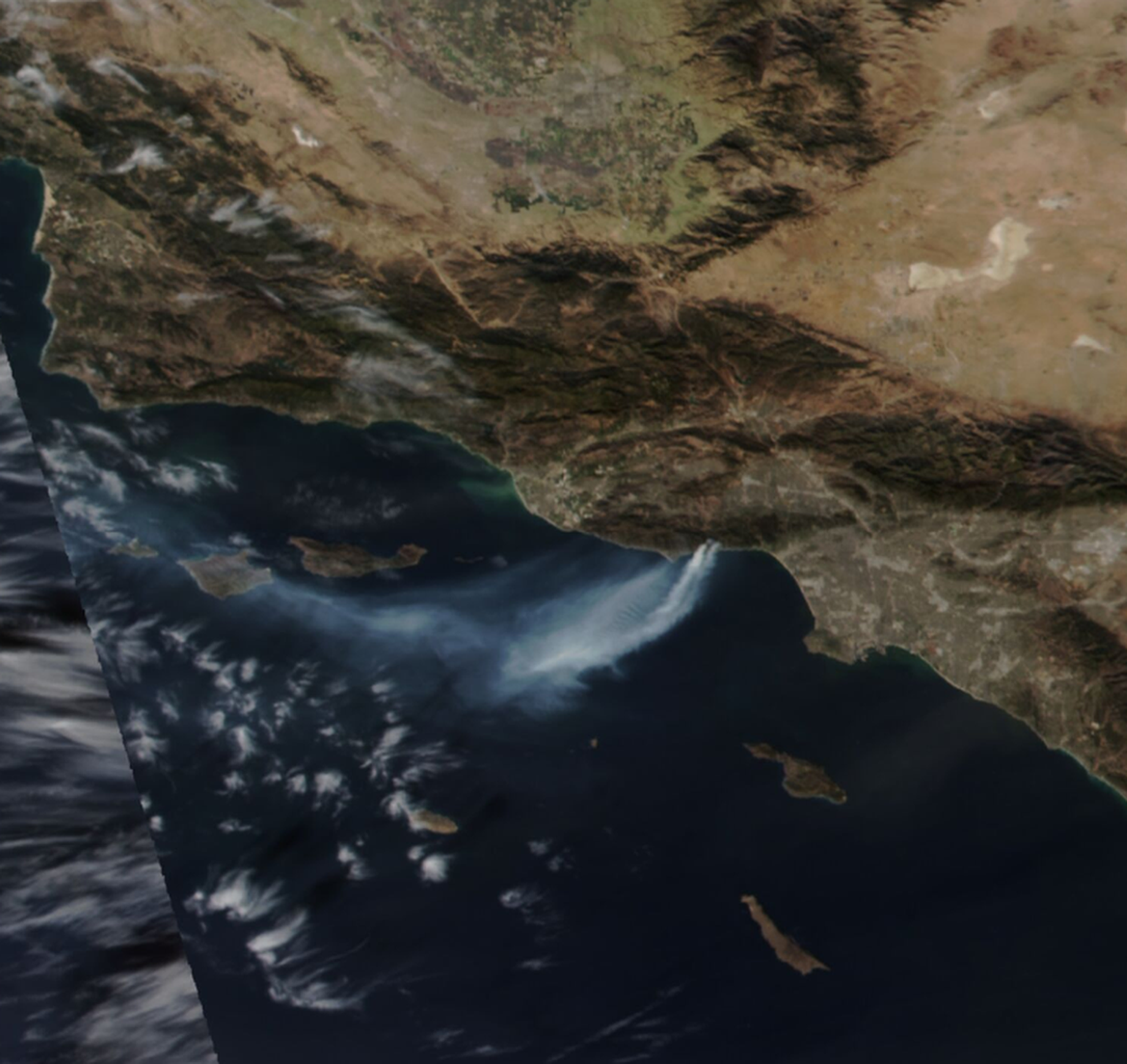 Southern California as seen from orbit, showing a plume of smoke arising from Malibu, CA