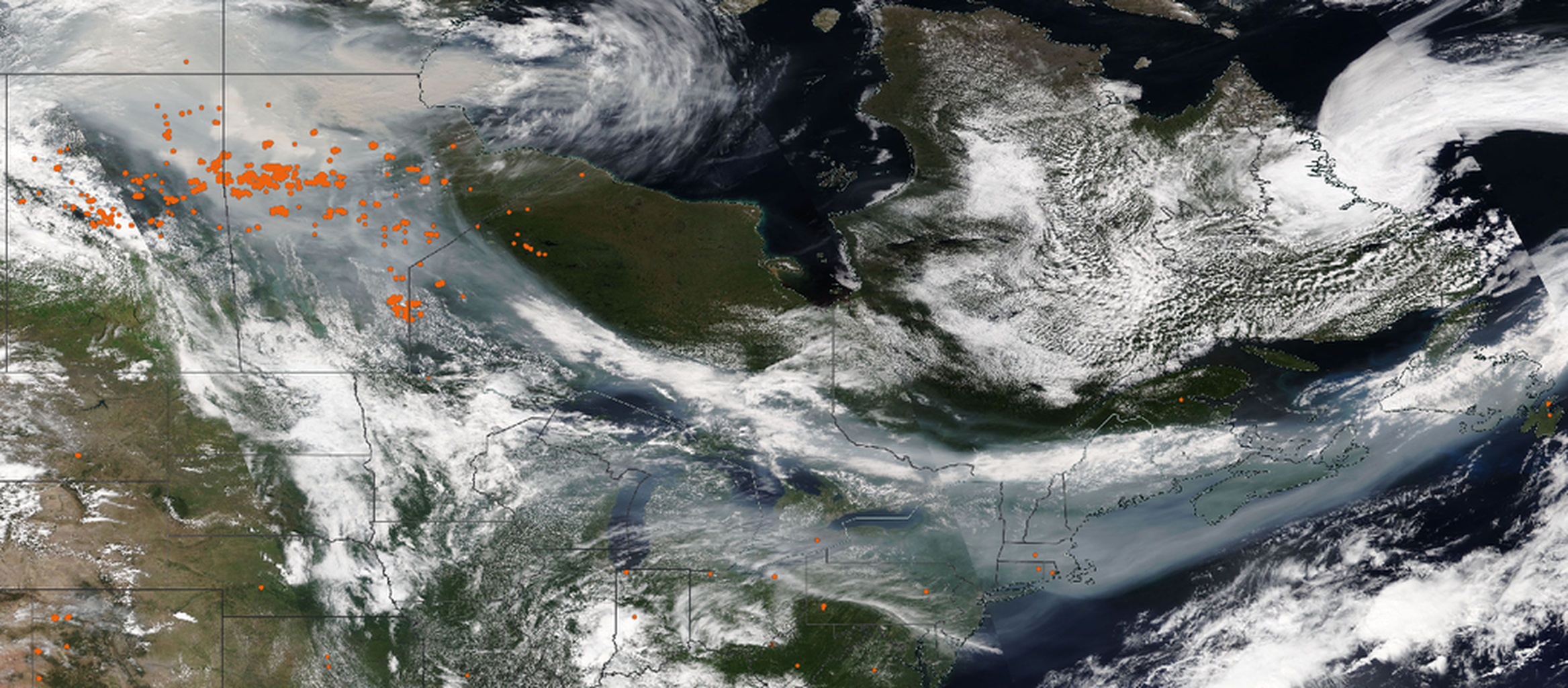 An image from Earth orbit above North America showing smoke from Canadian wildfires with false-color red dots indicating hotspots.