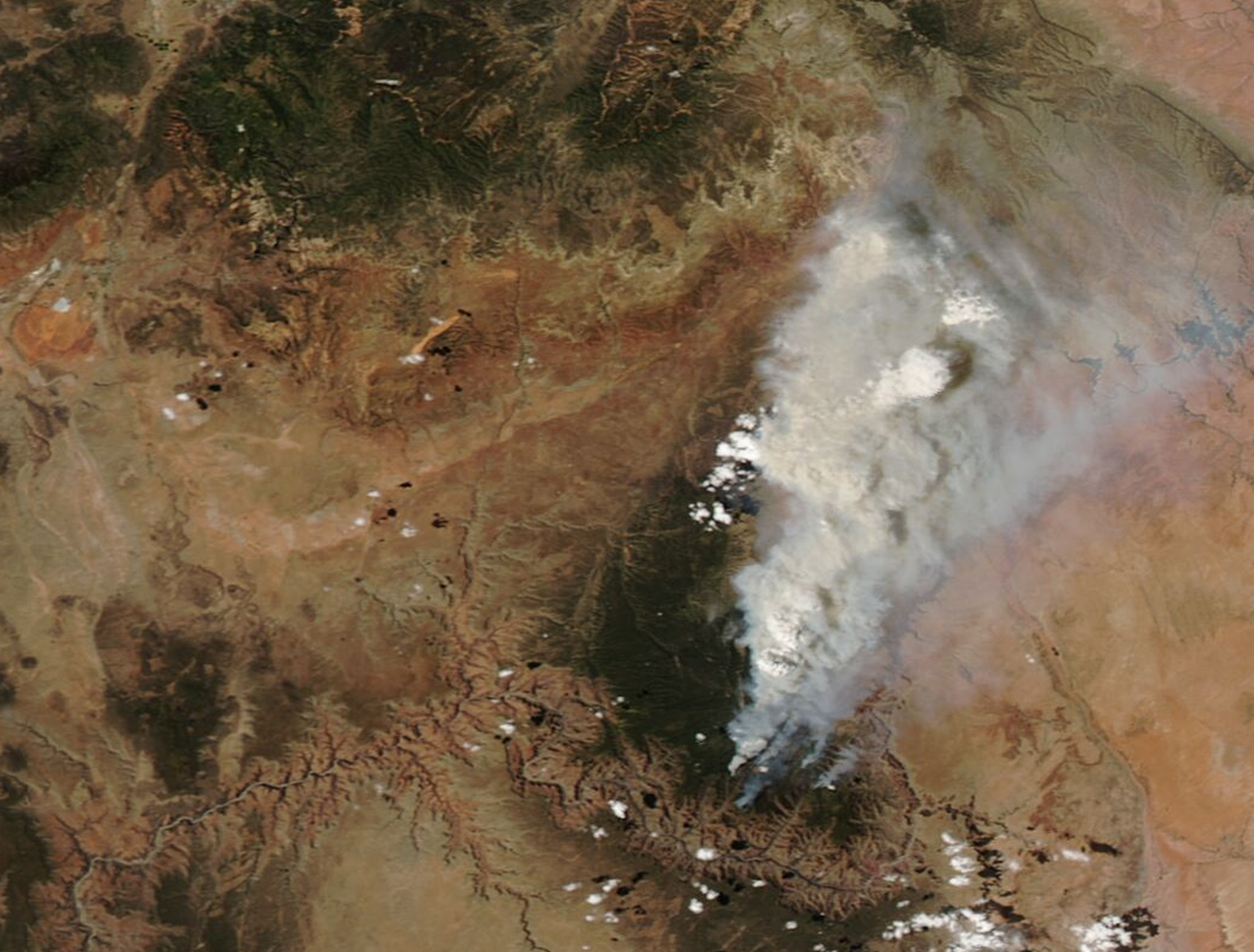 An image from Earth orbit above the Grand Canyon of the United States showing smoke rising to the sky.