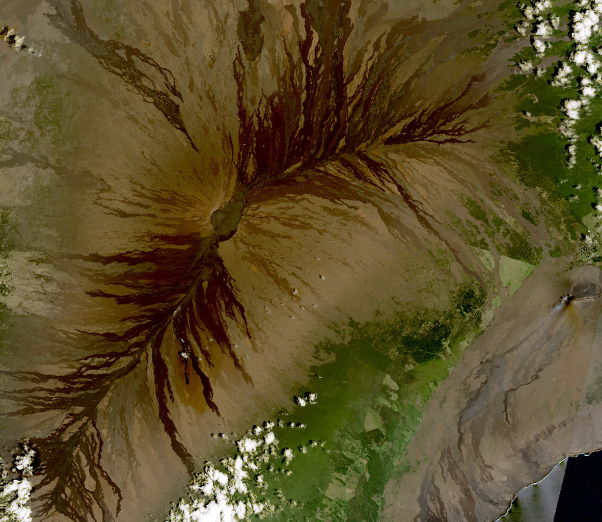 This is an image from Earth orbit showing the island of Hawaii, centered on the Mauna Loa and Kilauea volcanos. Kilauea shows a plume of smoke from the top of the dome of the volcano.