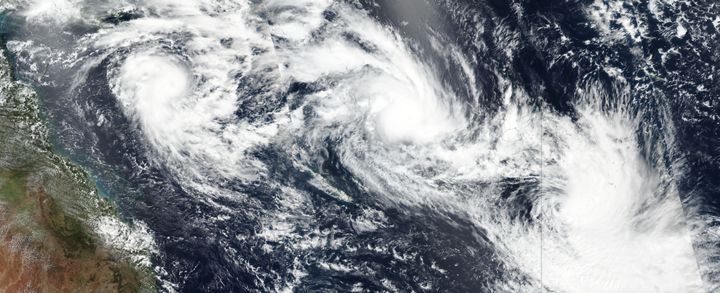 An image from Earth orbit of three tropical cyclones in a row in the Pacific Ocean.