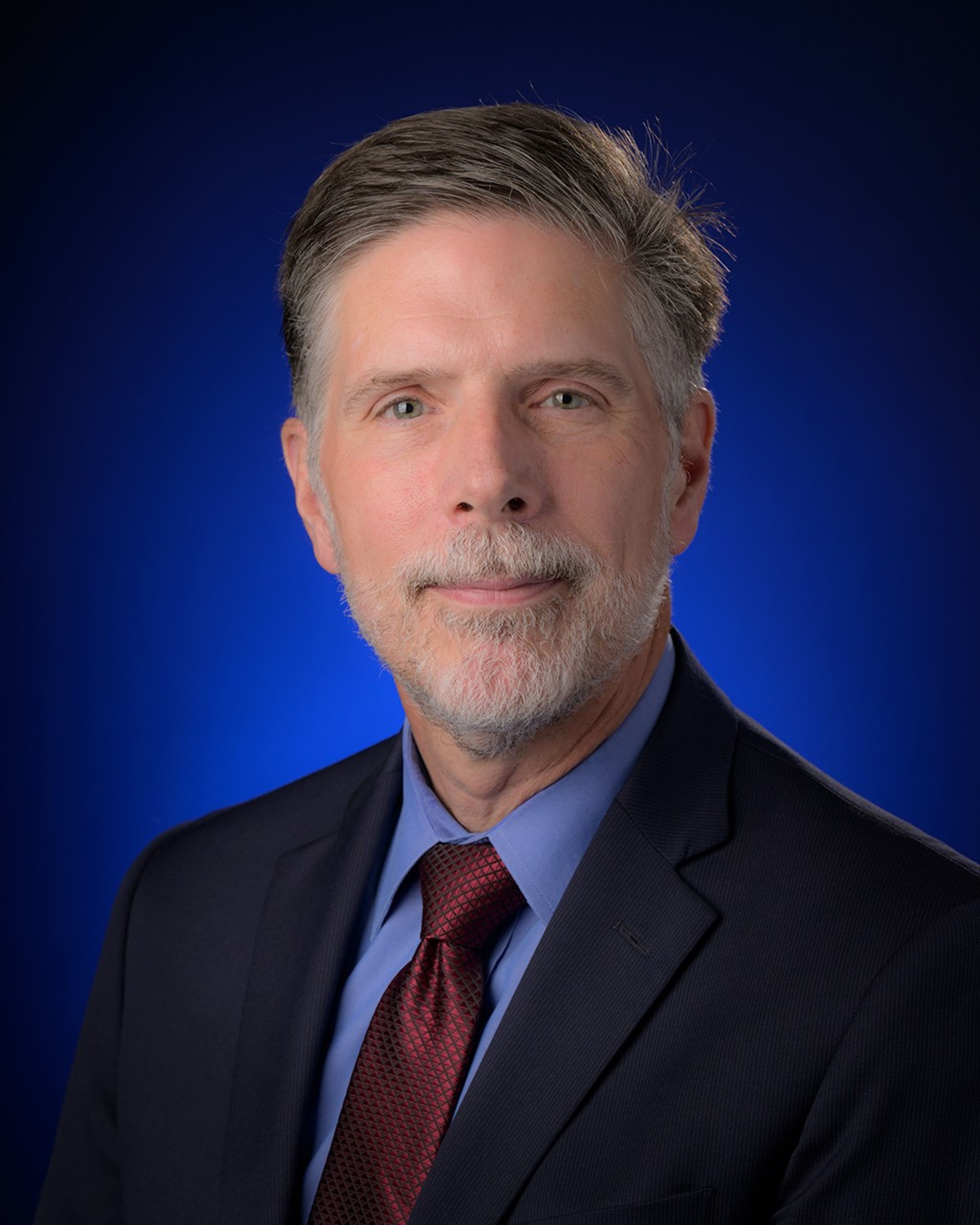 Portrait photo of a man wearing a suite and tie.