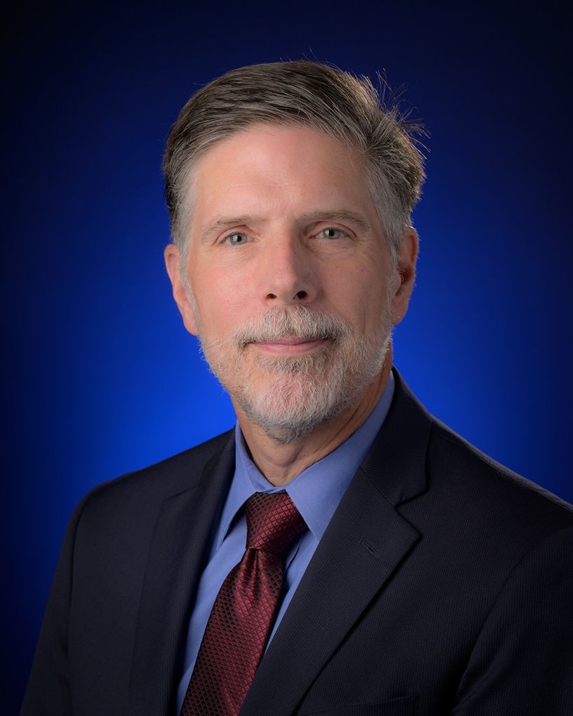 Portrait photo of a man wearing a suite and tie.