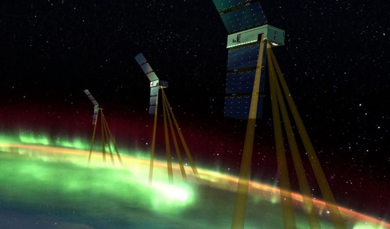 Art's representation of three EZIE spacecraft in space. Positioned above Earth, the EZIE spacecraft have brown beams directed at green aurora's to study space weather.
