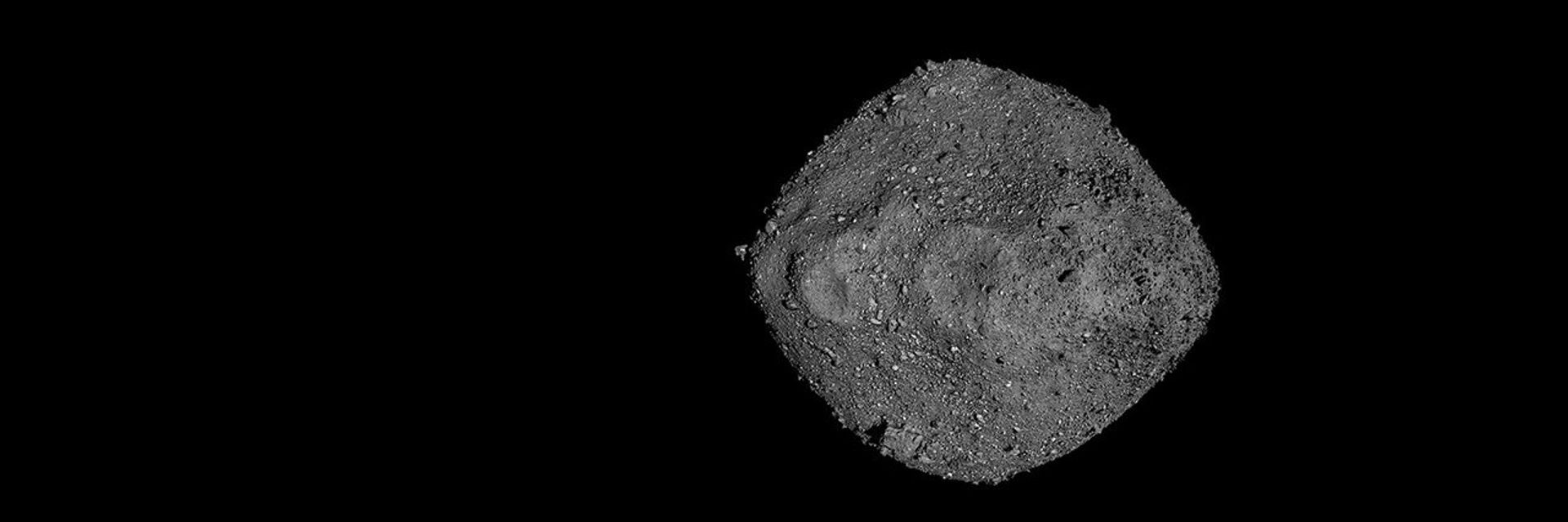 Primer plano de un asteroide rocoso con forma de diamante en el espacio.