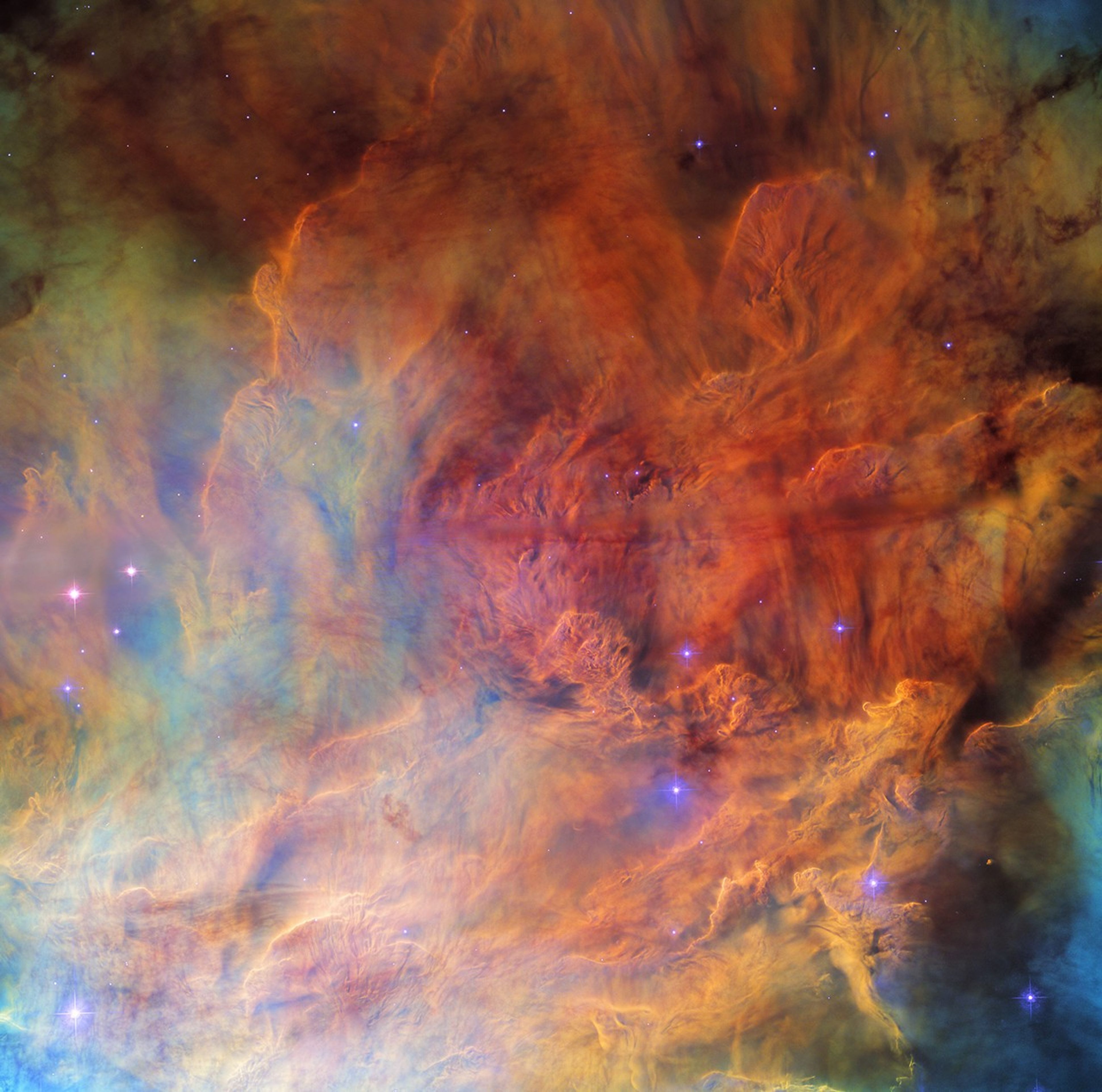 Nubes de gas cubren toda la vista, en una variedad de colores vivos. En el centro, el gas es más brillante y muy texturizado, pareciéndose a humo denso. En los bordes es más escaso y tenue. Varias estrellas pequeñas y brillantes de color azul están dispersas por la nebulosa.
