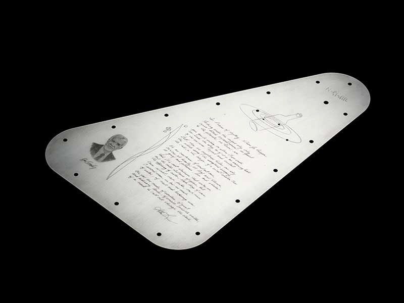 A full view of the Europa Clipper's triangular-shaped vault plate�s inward-facing side. It's engraved with symbols and poetry.
