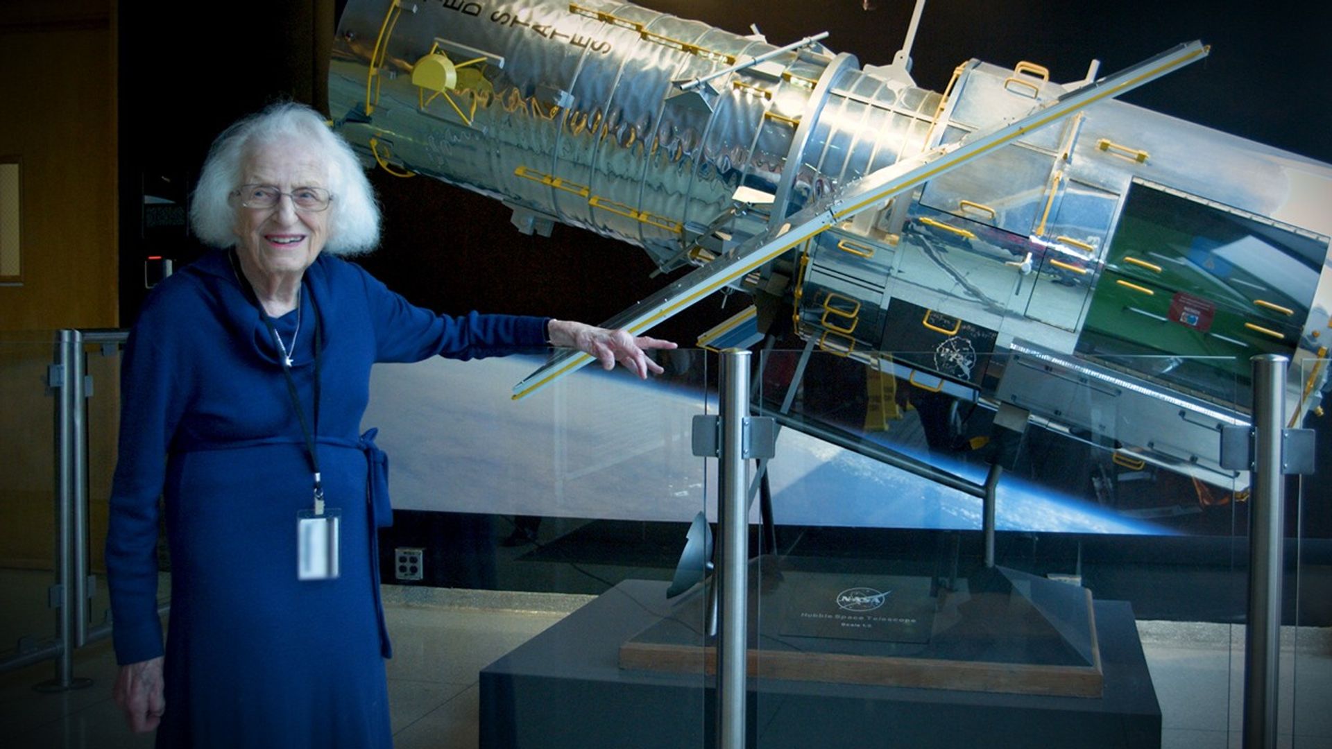 Nancy Grace Roman está de pie junto a una maqueta del telescopio espacial Hubble, en las afueras del centro de control de la misión de Hubble en el Centro de Vuelo Espacial Goddard de la NASA en Greenbelt, Maryland. Roman es conocida como la “madre del telescopio Hubble”.