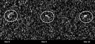 Una imagen pixelada en blanco, gris y negro, con tres manchas brillantes espaciadas en el centro y rodeadas de un círculo blanco.