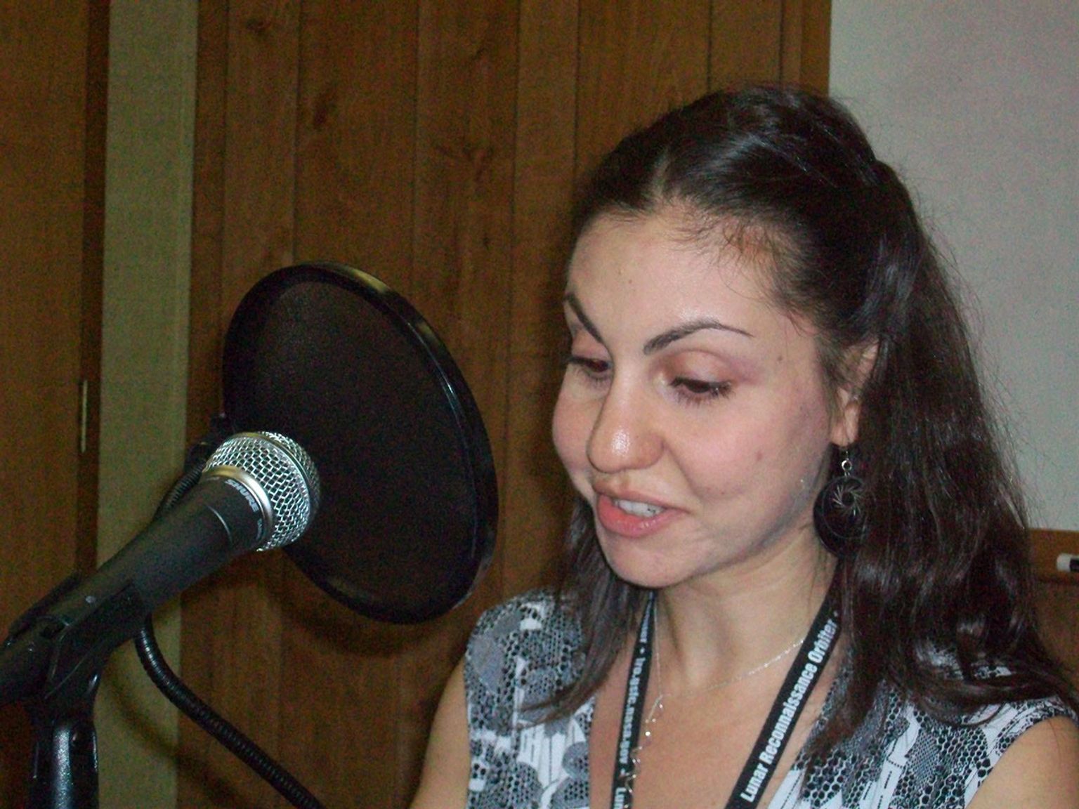 Svet in front of a microphone narrating a podcast.