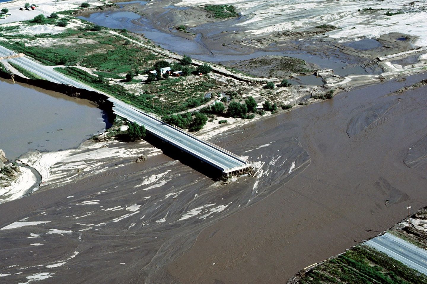 El agua de un río crecido por las lluvias durante El Niño de 1983 ocasionó daños en puentes y propiedades en el área de Tucson, Arizona.