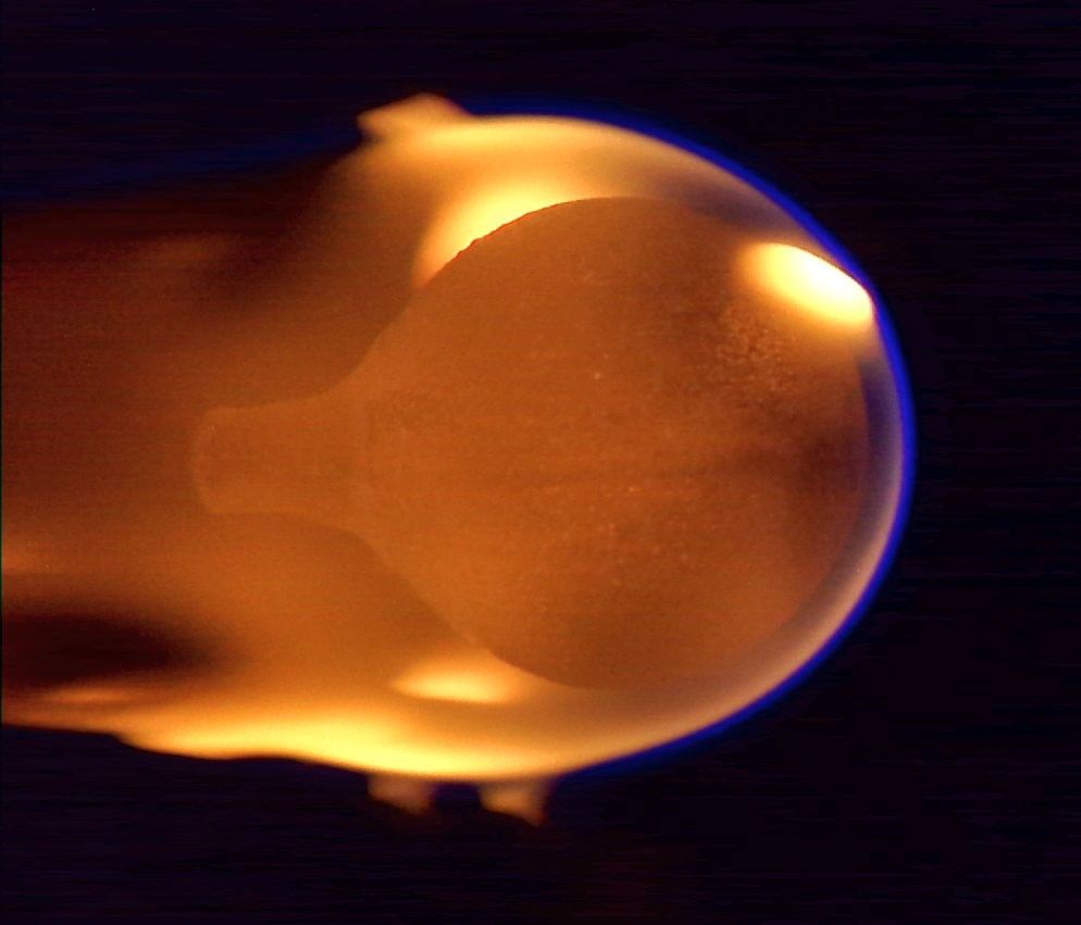 Esta imagen muestra una esfera de acrílico de 4 cm de diámetro ardiendo en microgravedad. La llama aparece cerca del final de la combustión, tras haber envuelto toda la esfera desde un pequeño punto de ignición situado en el lado derecho.