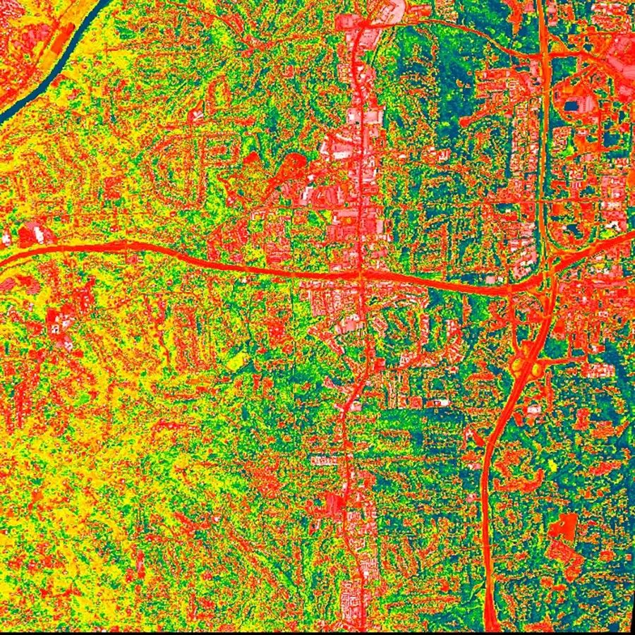 A satellite image showing temperatures across a suburban area, with roadways and other manmade surfaces significantly hotter than areas with vegetation.