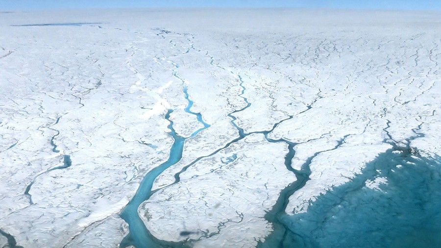 This aerial photograph shows fast-moving meltwater rivers flowing across the Greenland Ice Sheet.