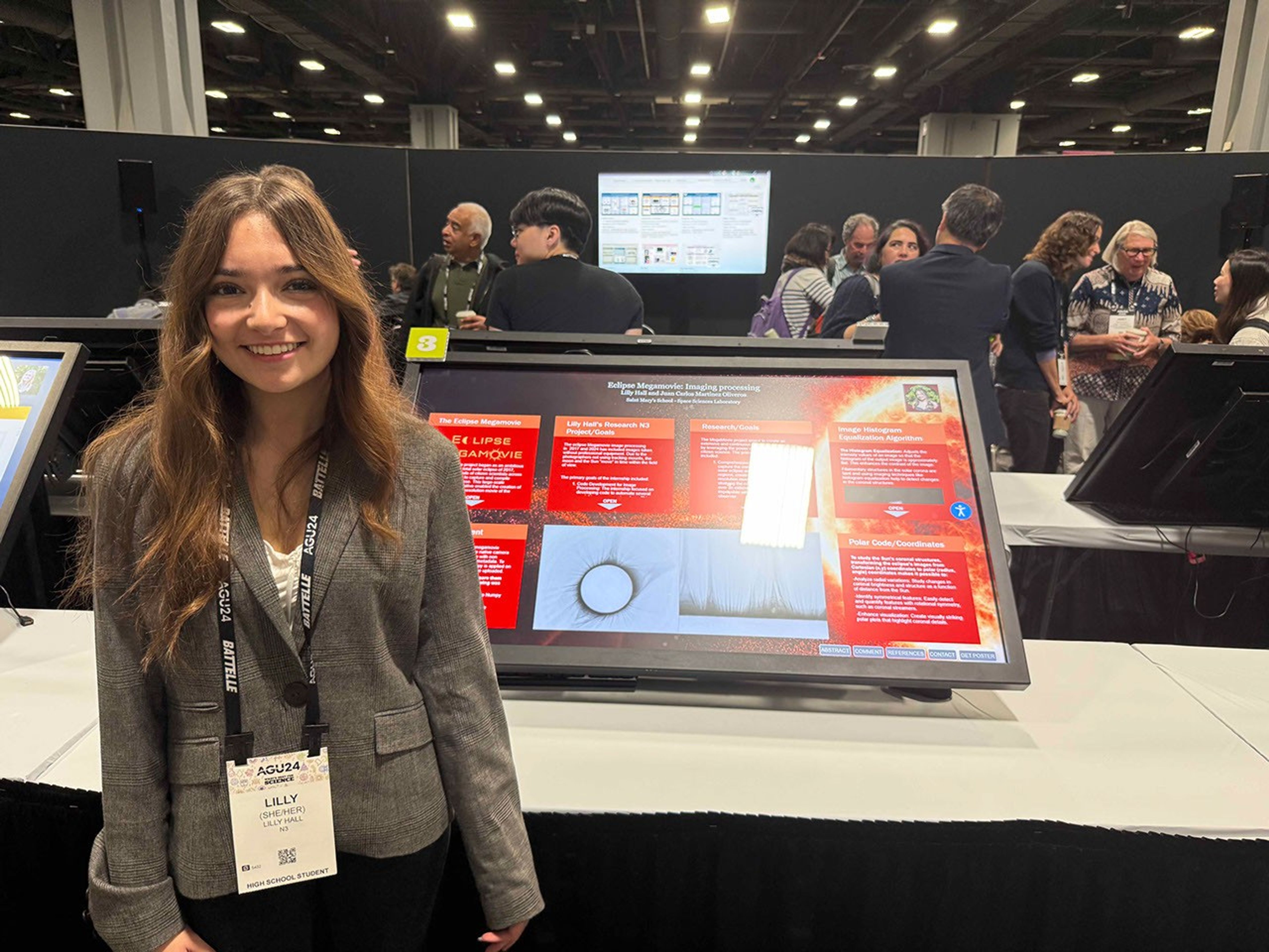 Lilly Hall stands in front of her Eclipse Megamovie Image Processing poster.