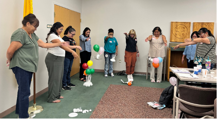 Nine workshops participants conducting a workshop activity that included dropping balloons (a "payload") from a height and securing their "vehicle".