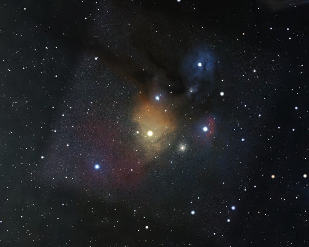 A digital map of the Rho Ophiuchi cloud complex, a colorful star-forming region in the constellation Ophiuchus. The image showcases the bright yellow-orange glow of the red supergiant star Antares at the center, surrounded by dusty dark nebulae and vibrant reflection nebulae. To the right, blue and red clouds indicate regions of reflection and emission, respectively, with multiple bright stars embedded in the clouds. The background is filled with a dense field of stars, contrasting with the dark dust lanes and colorful gas clouds.
