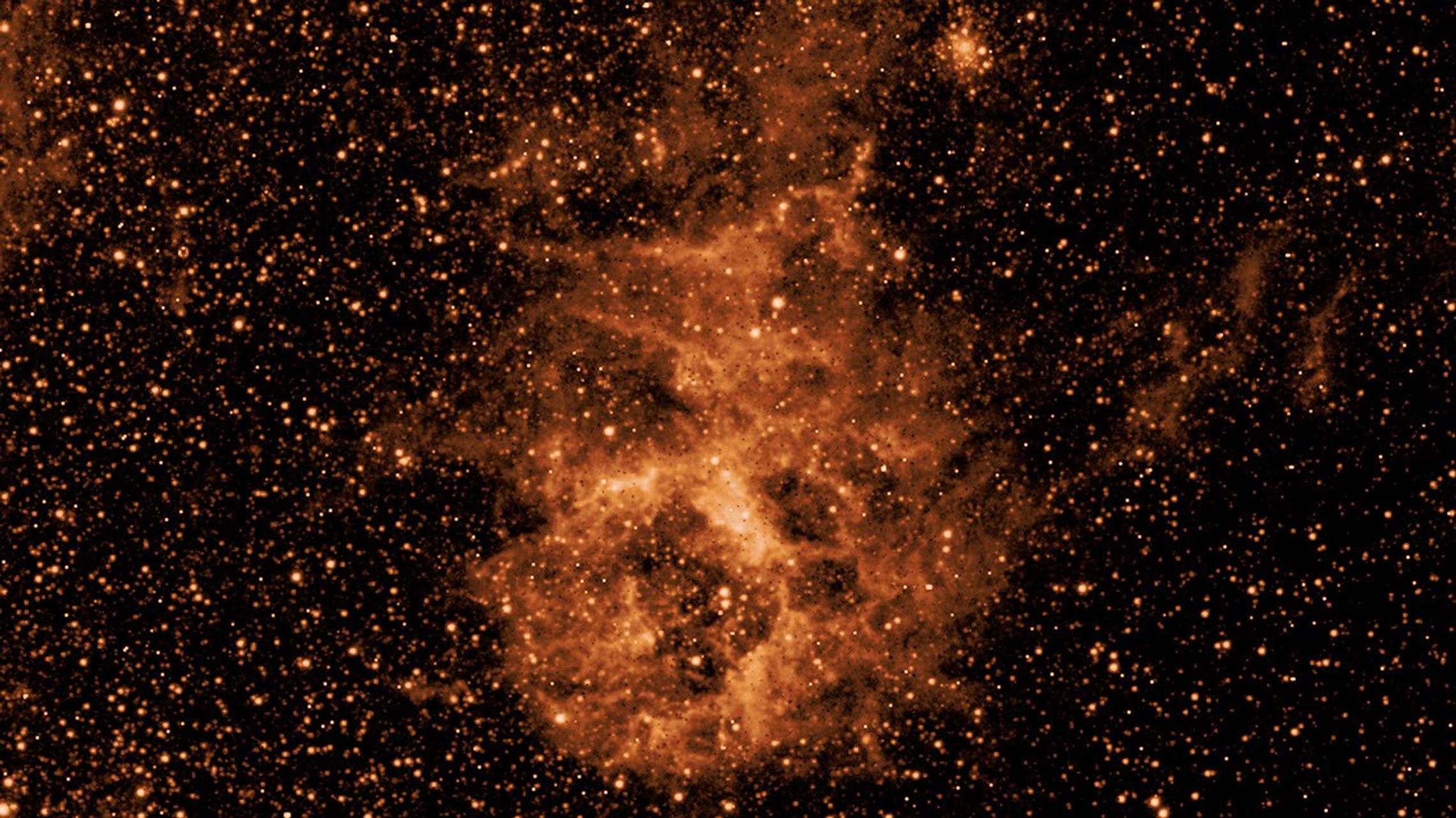 A cloud of dust imaged by SPHEREx in 3.29 microns, an infrared wavelength invisible to the human eye that has been adjusted to appear red in this image.