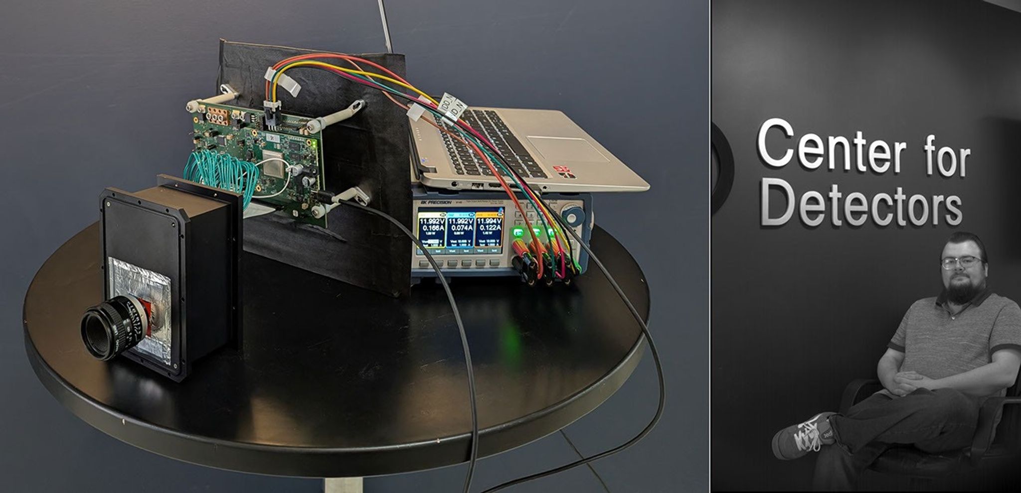 Left: A complex set of electronics on a table, including a sensor in a black box, a laptop, and interconnected cables. Right: A CfD staff member sitting in front of a sign reading Center for Detectors.