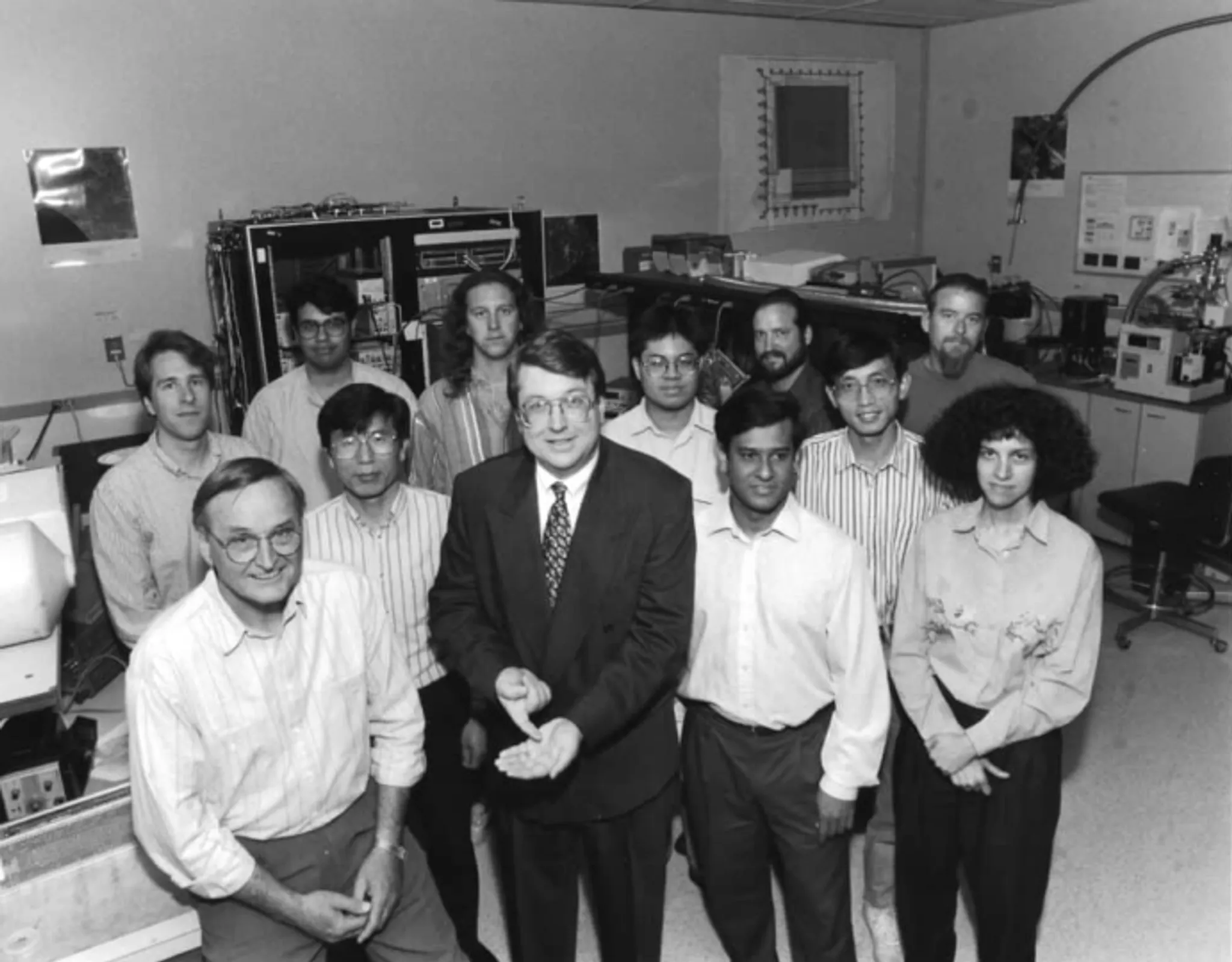 A group of people standing in a lab surrounded by technical equipment. 