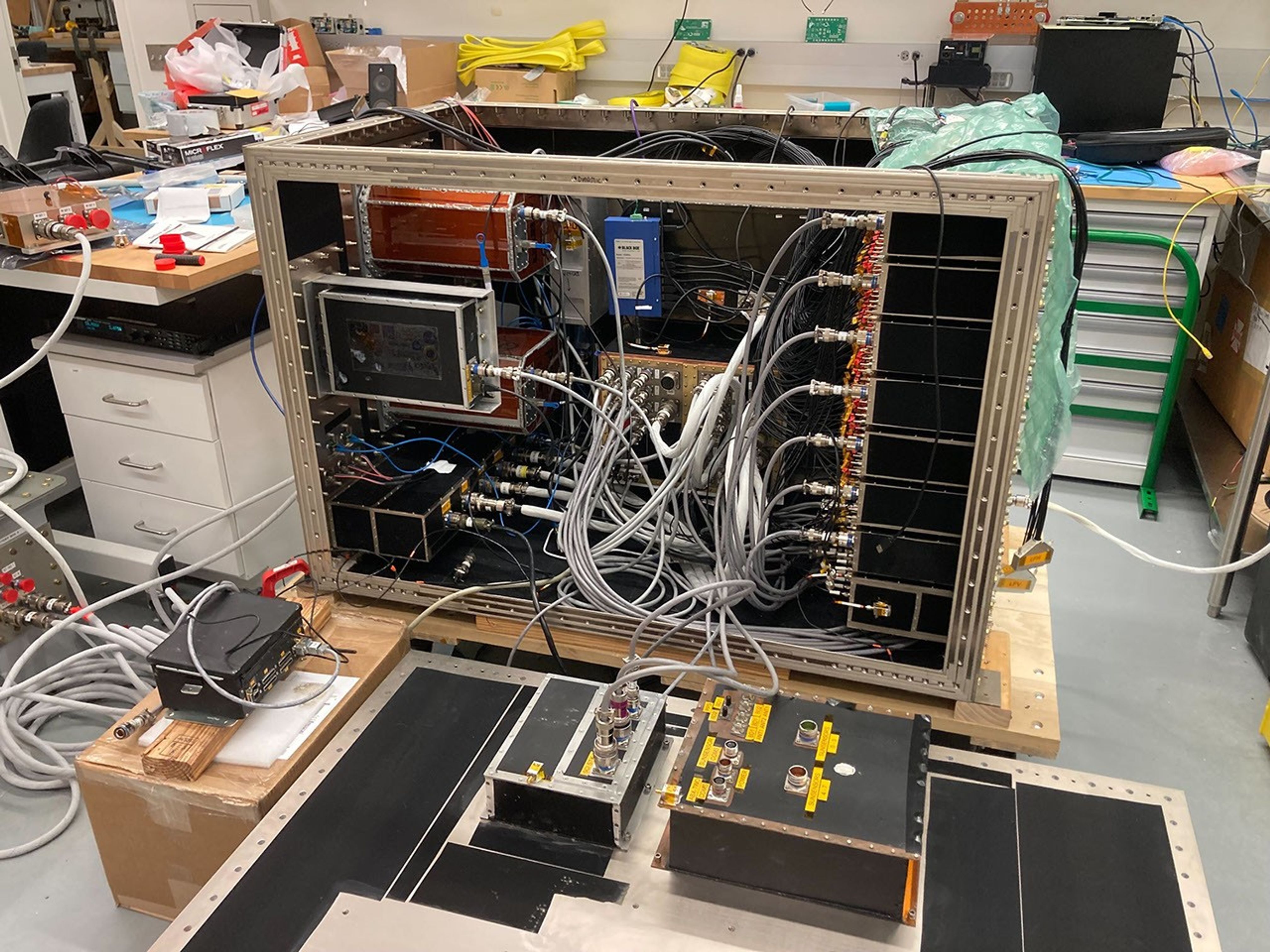 A rectangular structure containing components attached with wires on top of a workbench