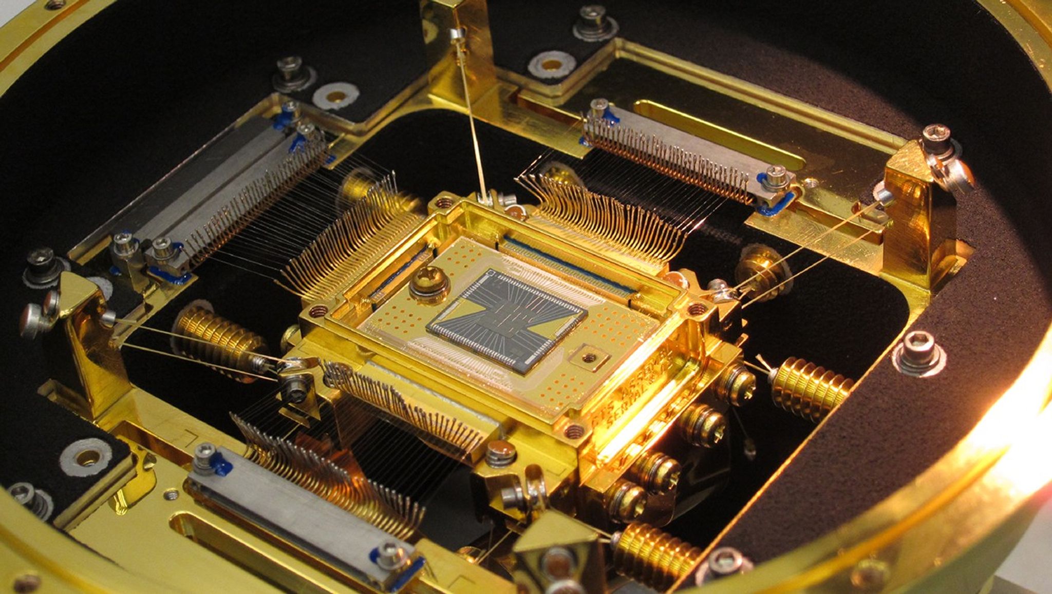 The heart of Hitomi's Soft X-ray Spectrometer is the microcalorimeter array at center. The five-millimeter square forms a 36-pixel array. Each pixel is 0.824 millimeter on a side, or about the width of the ball in a ballpoint pen. The detector's field of view is approximately three arcminutes, or one-tenth the apparent diameter of the full moon. Credit: NASA's Goddard Space Flight Center