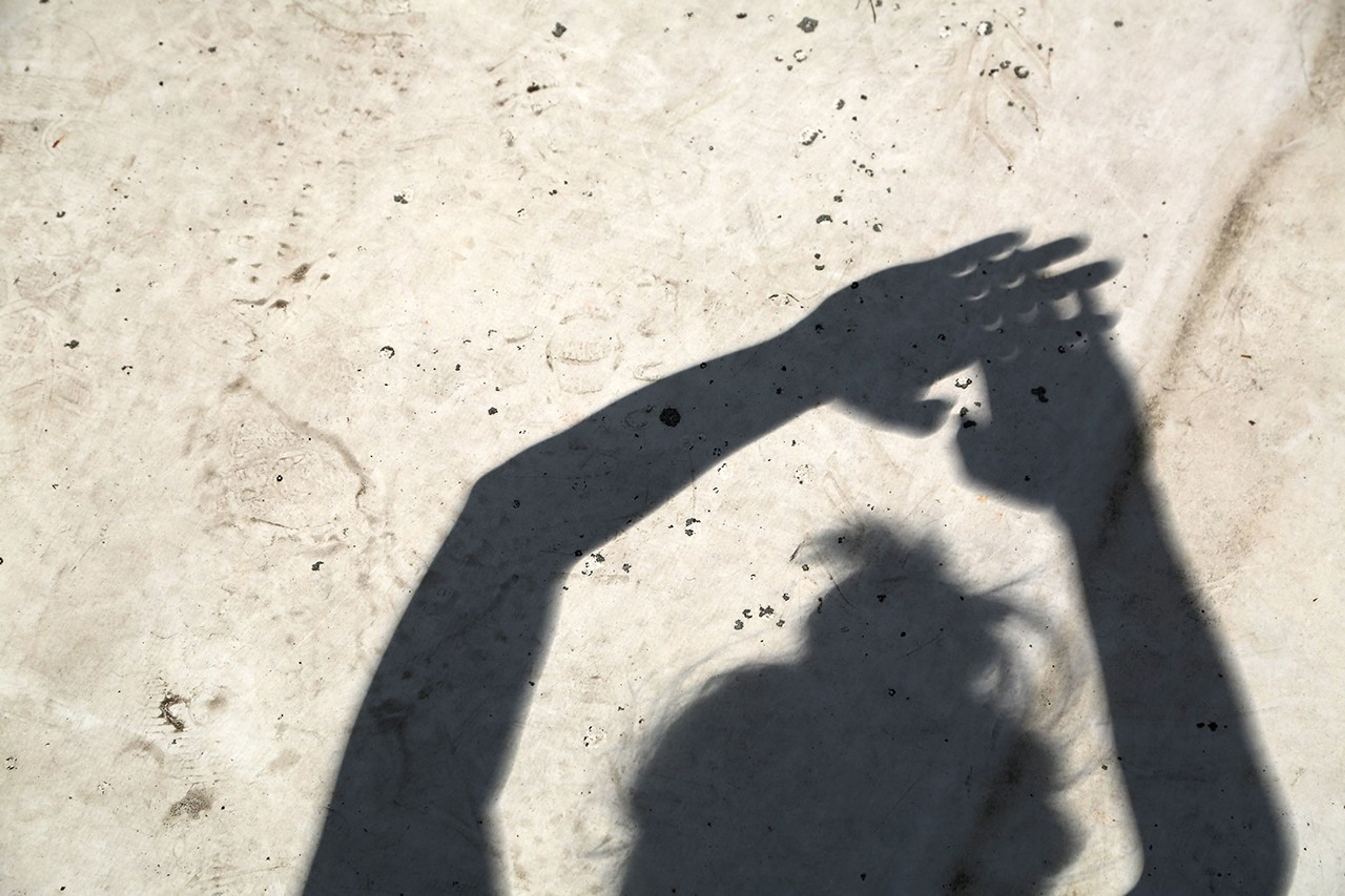 During the Aug. 21, 2017, total solar eclipse in Carbondale, IL, an eclipse watcher uses the small gaps in between their fingers to project several partial solar eclipse images on the ground. Credit: Sean Simmons