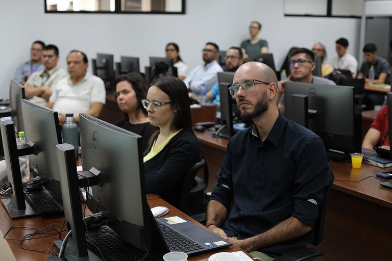 Participants sit at computer desks during the second ISAT workshop in March 2024. In the front row, from right to left, are Tiago Pohren, Vanessa Erasun, and Florencia Hastings.