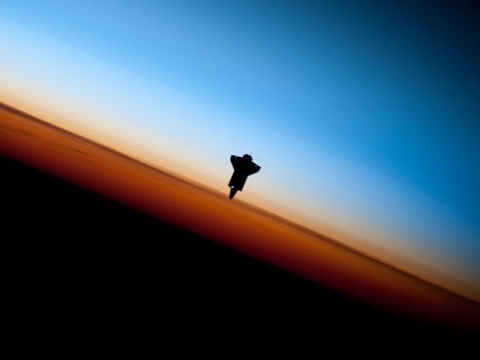 ENDEAVOUR: Some of the most breathtaking views of Earth taken from space are those that capture our planet's limb. When viewed from the side, the Earth looks like a flat circle, and the atmosphere appears like a halo around it. This edge of the atmosphere is known as the limb. Viewed from space, the image of this luminous envelope of gases shielding life on our planet from the dark, cold space beyond rarely fails to fascinate us. What makes this image even more fascinating is the added silhouette of the space shuttle Endeavour. The orange layer seen is the troposphere, where all of the weather and clouds that we typically experience are created and contained. The troposphere gives way to the whitish stratosphere and then mesosphere. This image was captured by an astronaut prior to Endeavour's rendezvous and docking with the International Space Station on February 9, 2010.