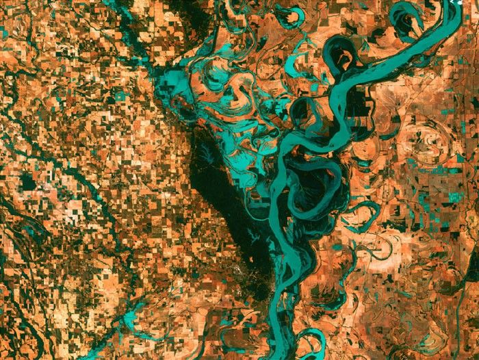 MEANDERING MISSISSIPPI: Small, blocky shapes of towns, fields, and pastures surround the graceful swirls and whorls of the Mississippi River. Countless oxbow lakes and cutoffs accompany the meandering river south of Memphis, Tennessee, on the border between Arkansas and Mississippi, USA. The 'mighty Mississippi' is the largest river system in North America. Image taken by Landsat 7 on May 28, 2003.