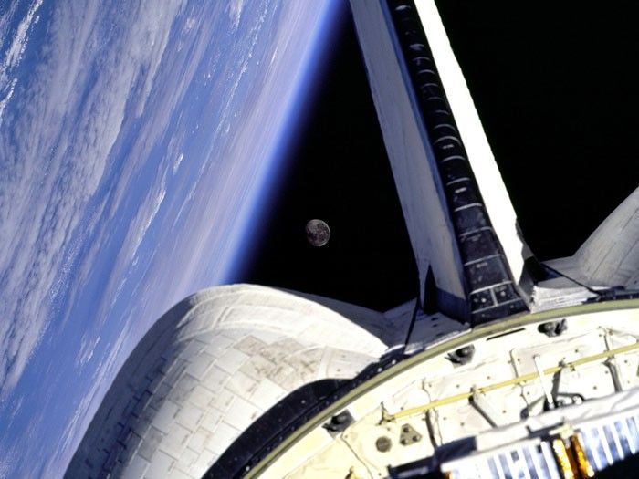 MOON FRAME: Earth and its Moon are nicely framed in this image taken from the aft windows of the Space Shuttle Discovery in 1998. Discovery, on mission STS-95, was flying over the Atlantic Ocean at the time this image was taken.