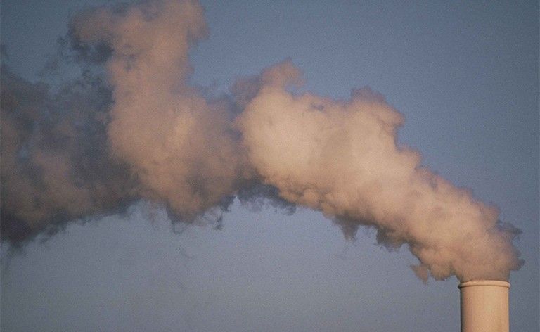 Humo de contaminación atmosférica saliendo de la torre de una planta. 