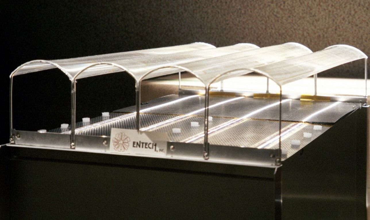 In the Stretched Lens Array, a descendant of SCARLET, a thin film studded with tiny prisms is stretched between arches to help it focus sunlight onto solar cells below.