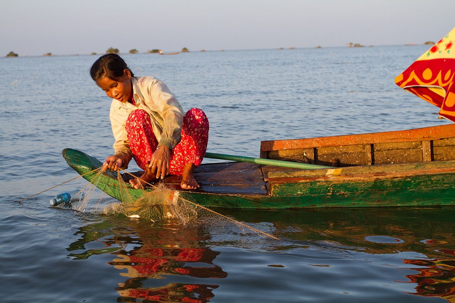 A person fishing at sunset on Tonlé Sap Lake, near Akal village in Cambodia.