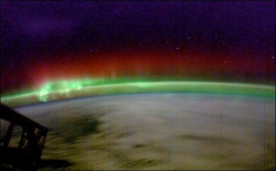 Photograph of green aurora topped by red.