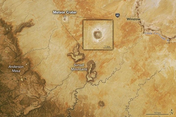 In the upper left of center of the image a meteor crater is labeled below route 40. Sunset Mountains center in the image and the Anderson Mesa occupies the lower left edge of the image, darker in color than the yellow landscape that dominates the image.