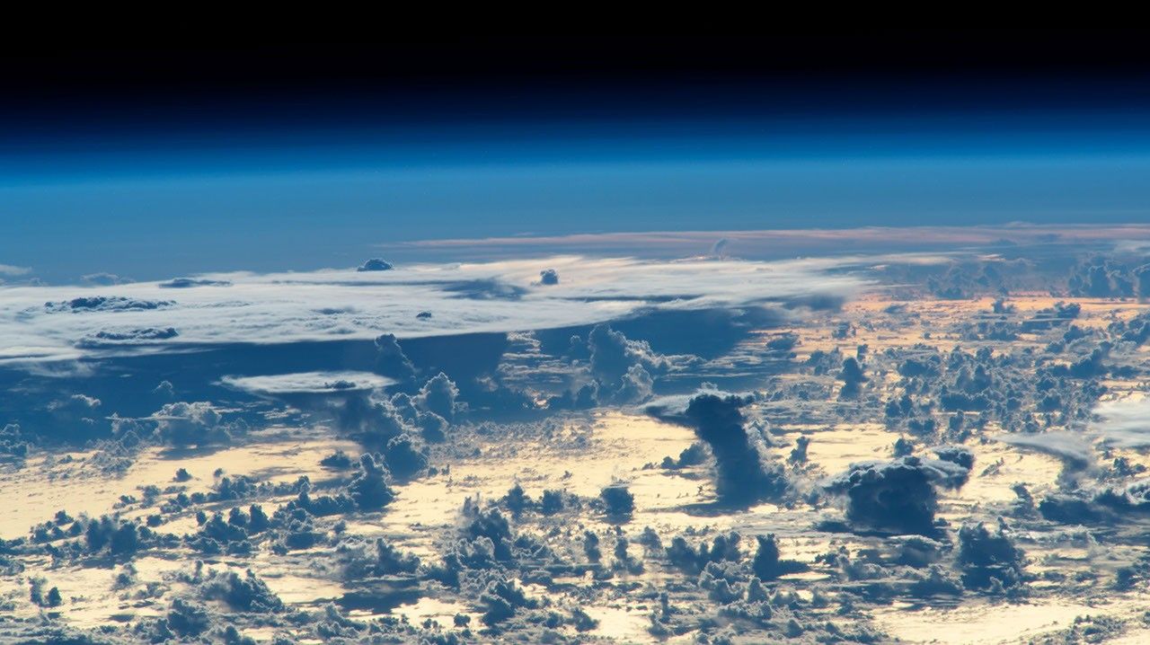 Towering cumulus clouds at dawn over the northwest Atlantic, photographed from the ISS — each cloud is a rising parcel that has reached its lifting condensation level