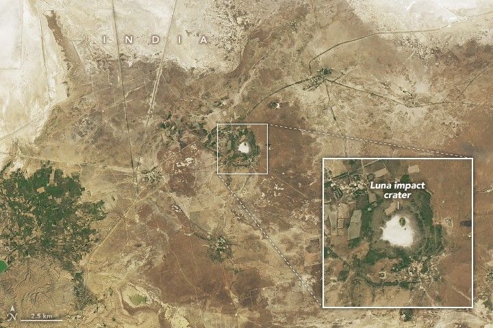 in the light brown dusty landscape is a near white spot surrounded in by pale green. This is zoomed in on in a pop out box and labeled Luna impact crater. More foliage appears in the lower left of the image in a gridded pattern.
