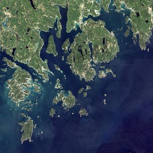 Acadia National Park is one of the most visited parks in America, drawing more than 2.5 million visitors per year to the craggy, jagged coast of Maine. The park is celebrating its 100th anniversary in 2016. On September 6, 2015, the Operational Land Imager (OLI) on the Landsat 8 satellite acquired these images of Acadia National Park and its surroundings. Mountains and hills roll right up to the Atlantic Ocean in this rocky landscape carved by glaciers at the end of the last Ice Age. Since the beginning of the 20th Century, the park has been pieced together by donations and acquisitions of once-private lands, and it is still growing. Of the park’s 47,000 acres, more than 12,000 are privately owned lands under conservation agreements, while the rest is held by the National Park Service. Mount Desert Island is the focal point of the park, which also includes lands around a former naval base (Schoodic Peninsula), Isle au Haut, and several smaller islands.